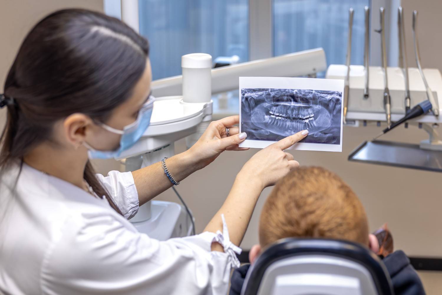 Young female dentist showing a patient a dental X-ray